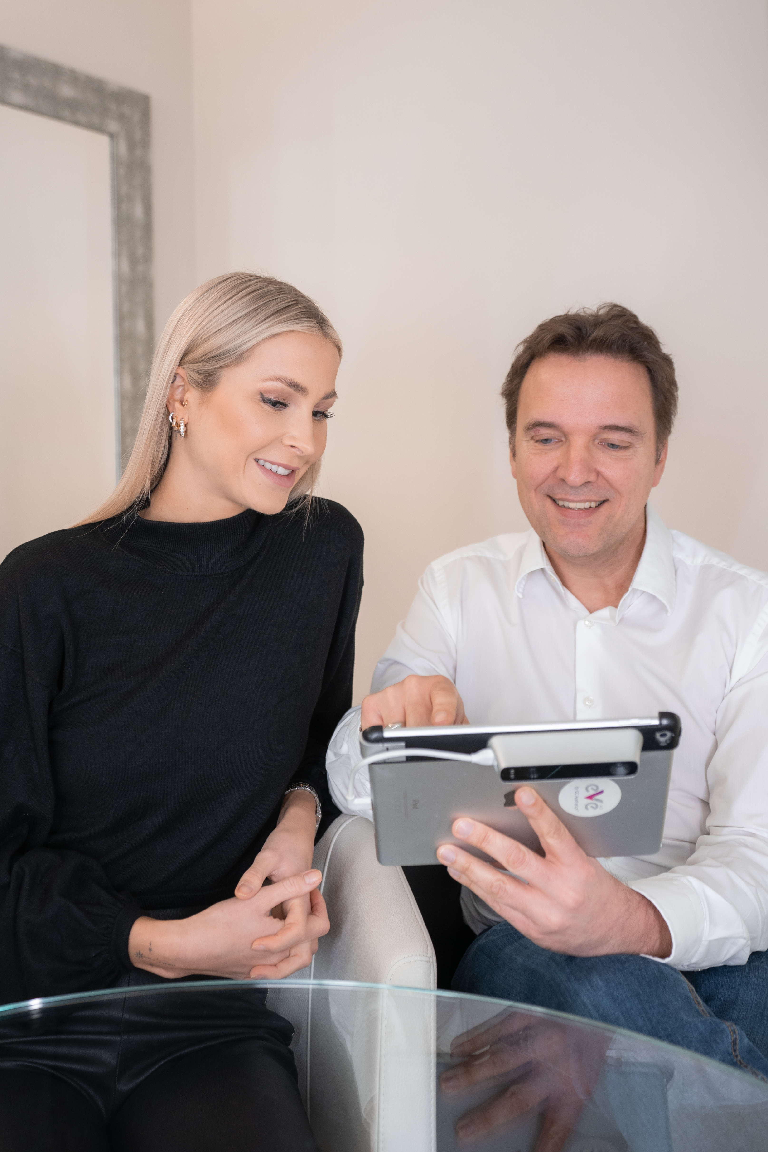 Dr. Christian Döbler berät Patientin und zeigt ihr Bilder auf seinem Tablet