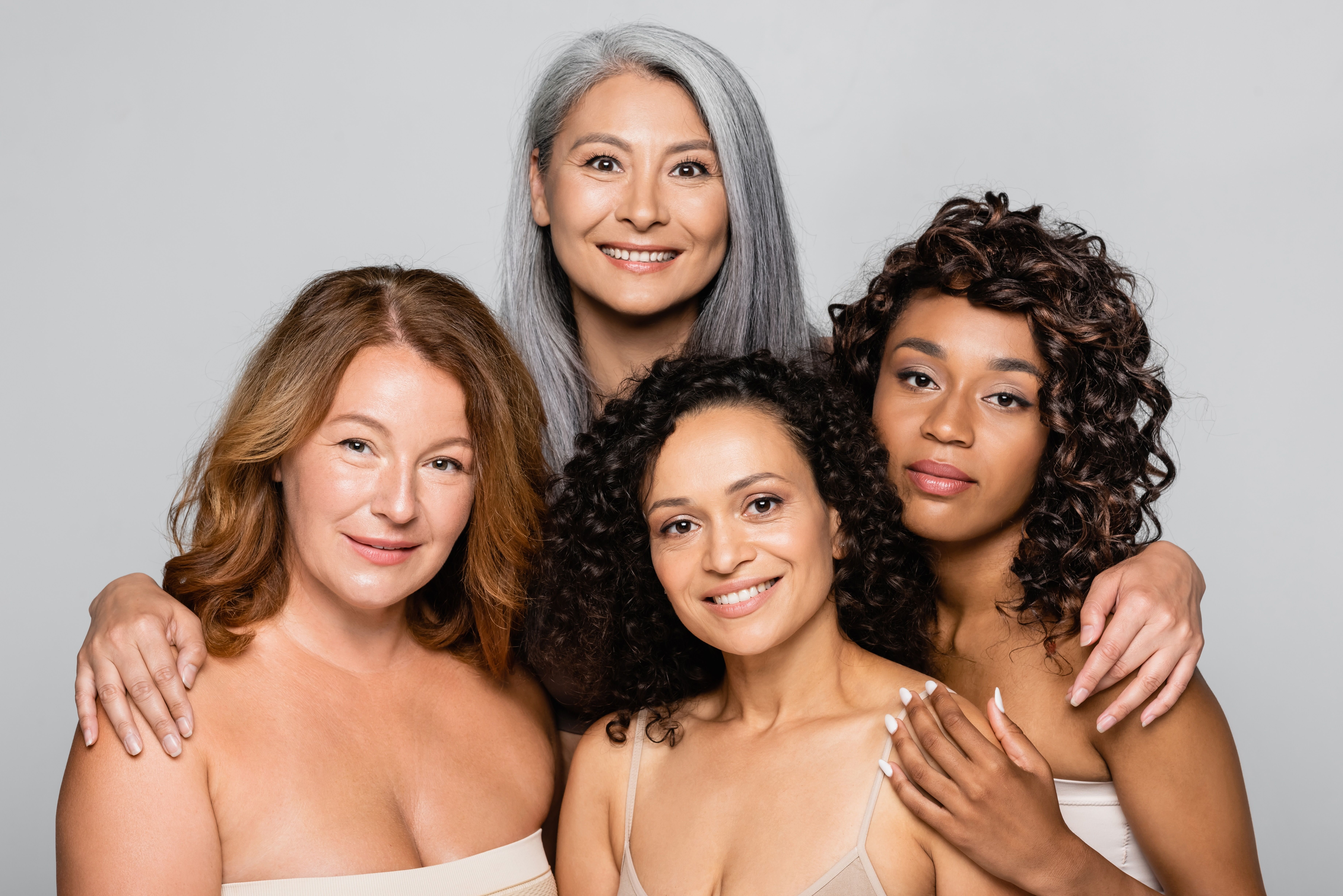 Vier Frauen mit unterschiedlichem Hauttyp und Körpergrößen zeigen ihre Oberweite