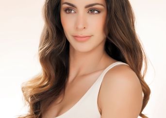 Junge brünette Frau mit Brüsten mit Silikonimplantaten