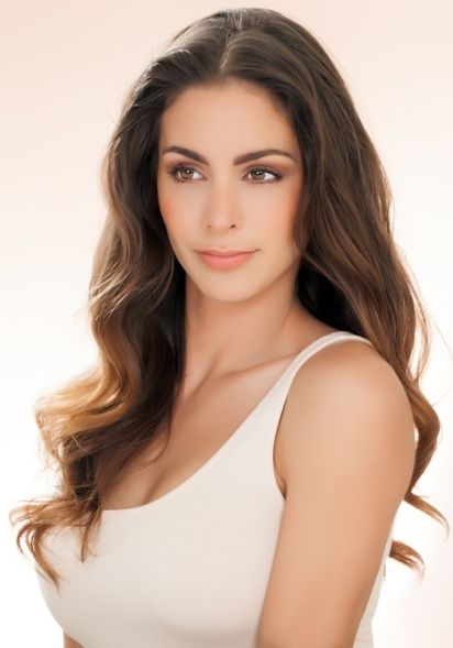 Junge brünette Frau in beigem Top mit schön geformten Brüsten