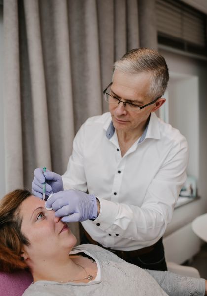 Dr. Roman Lisovets mit Patientin während Botox Unterspritzung in Stirn